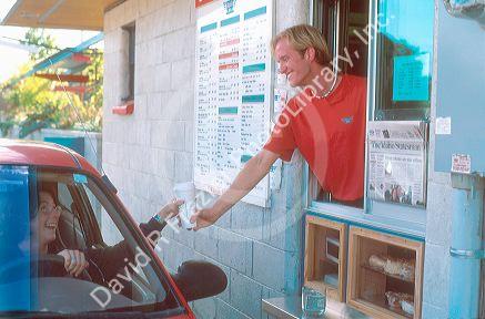 Customer getting her morning coffee from a drive up window.