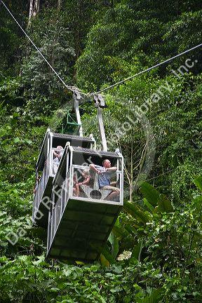 Tourists ride an aerial tram ride through the rainforest canopy of Veragua Rainforest Research and Adventure Park near Limon, Costa Rica.