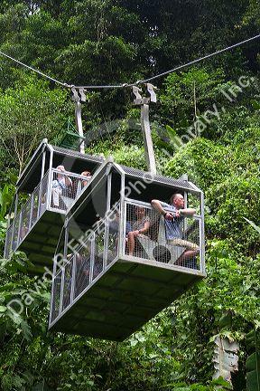 Tourists ride an aerial tram ride through the rainforest canopy of Veragua Rainforest Research and Adventure Park near Limon, Costa Rica.