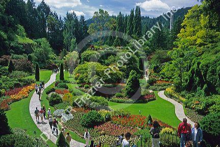 People walking on a pathway through Butchard Garden in Victoria, British Columbia, Canada.