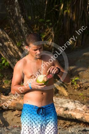 Man with a tropical drink at the Manuel Antonio National Park in Puntarenas province, Costa Rica.