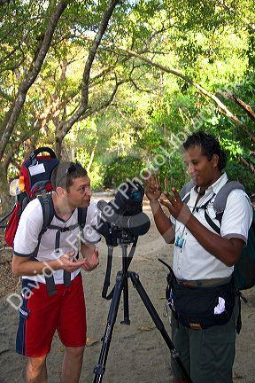Tourist and nature guide look at wildlife through a telescope in the Manuel Antonio National Park in Puntarenas province, Costa Rica.