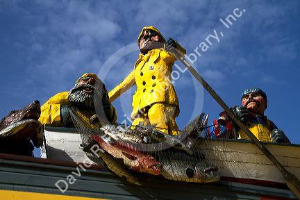 Exterior wooden sculpture of fishermen on the waterfront in Seattle, Washington, USA.