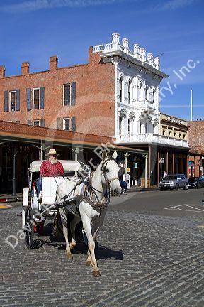 Tourists ride in a horse drawn carriage at Old Sacramento State Historic Park in Sacramento, Califorina, USA.