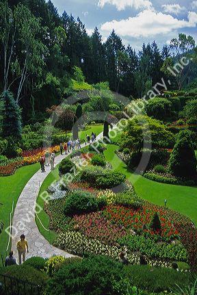 People walking on a pathway through Butchard Garden in Victoria, British Columbia.