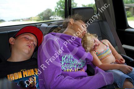 Children asleep in the backseat of a truck after a long day of fishing in Florida, USA.