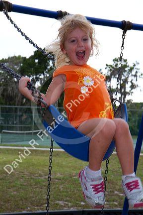 3 year old girl swinging on a swingset in Brandon, Florida, USA. MR