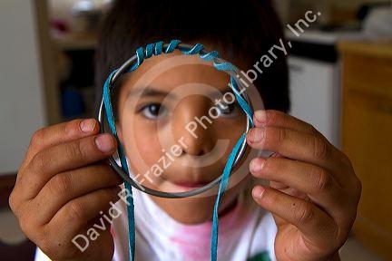 Native Pueblo boy crafting dreamcatchers in San Felipe Pueblo, New Mexico, USA.