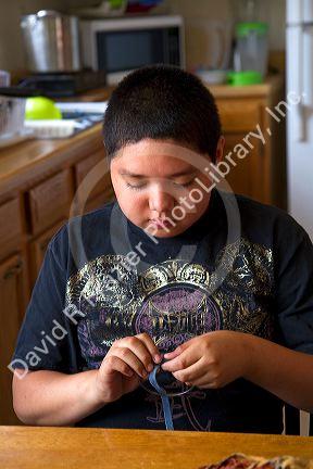 Native Pueblo boy crafting dreamcatchers in San Felipe Pueblo, New Mexico, USA.