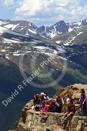 Tourists view the Rocky Mountains from a scenic overlook in the Rocky Mountain National Park, Colorado, USA.