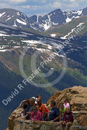 Tourists view the Rocky Mountains from a scenic overlook in the Rocky Mountain National Park, Colorado, USA.