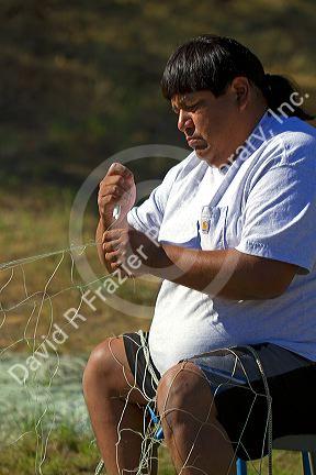 Yakama Nation indian repairing fishing nets at Celilo Village on the Columbia River, Oregon, USA. MR