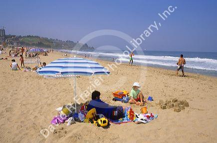 A beach scene with adults and children in  Renaca, Chile.