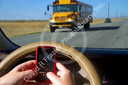 Text messaging on a cell phone while driving in Idaho, USA. MR