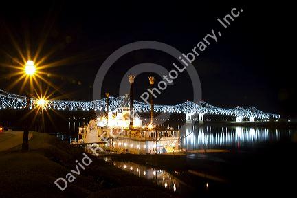 Steamboat docked at night near the Natchez-Vidalia Bridges spanning the Mississippi River between Vidalia, Louisiana and Natchez, Mississippi, USA.