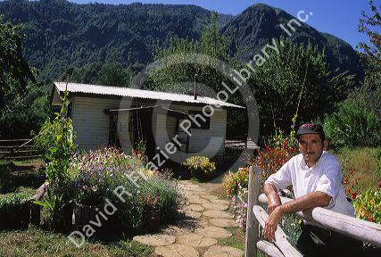 A chilean man and his home in the rural mountain area near Villarica, Chile.