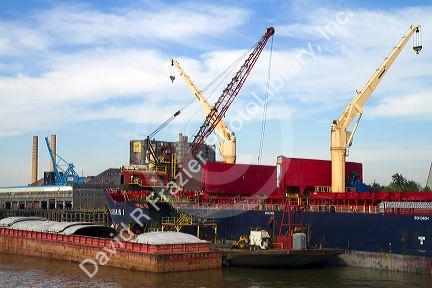 Crane loading a barge with coal on the Mississippi River at New Orleans, Louisiana, USA.