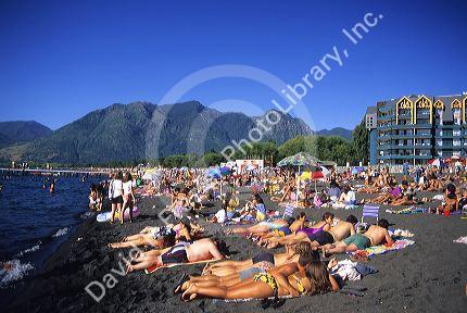People sunbathing on a black sand beach at Villarica Lake in Pucon, Chile.