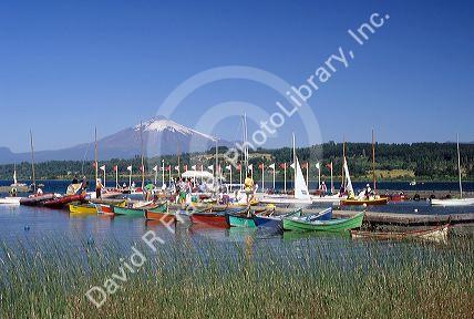 Boats docked at a marina with Villarica volcano in Villarica, Chile.