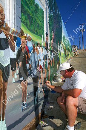 Artist painting a mural in Vicksburg, Mississippi, USA.