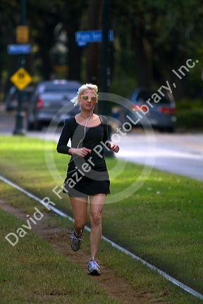Woman jogging on the St. Charles Streetcar Line in the Garden District of New Orleans, Louisiana, USA.
