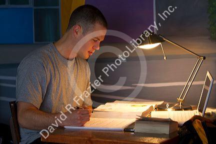 Male student studying a textbook in Boise, Idaho, USA.