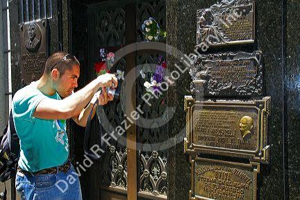Tourist taking a photo of the bronze plaque marking Eva Peron mausoleum in La Recoleta Cemetery, Buenos Aires, Argentina.