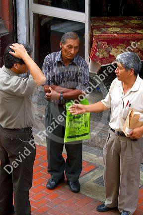 Peruvian men talk on the street in Lima, Peru.