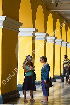 Yellow porticos lead to the entrance of the Plaza Mayor or Plaza de Armas of Lima, Peru.