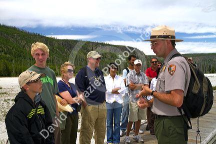 Park ranger giving a tour group information about the Upper Geyser Basin in Yellowstone National Park, Wyoming, USA.