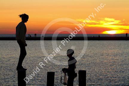 People watch the sunset on Lake Michigan at Pere Marquette Harbor located in Ludington, Michigan, USA.