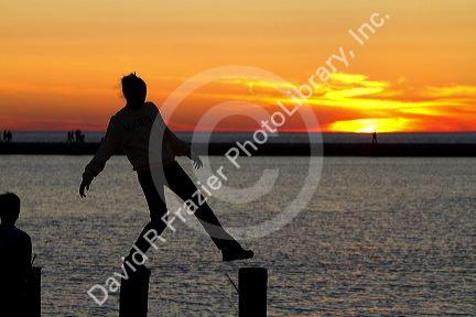 People watch the sunset on Lake Michigan at Pere Marquette Harbor located in Ludington, Michigan, USA.