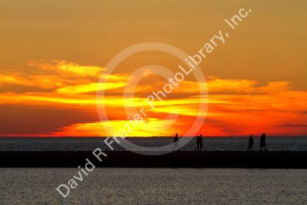 People watch the sunset on Lake Michigan at Pere Marquette Harbor located in Ludington, Michigan, USA.