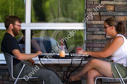 Modern couple using laptop personal computers at a coffee shop in Boise, Idaho, USA.