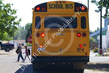 School bus stop with children crossing the street in Notus, Idaho, USA.