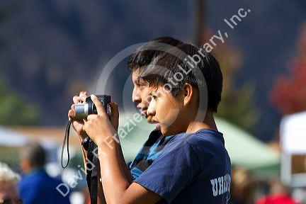 Hispanic boys using a digital cameras to capture images of the Trailing of the Sheep Festival in Hailey, Idaho, USA.