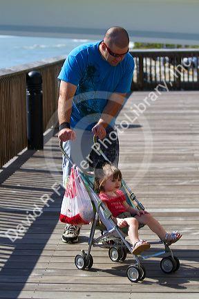 Family on the boardwalk at Johns Pass Village located on the waterfront at Madeira Beach, Florida, USA.