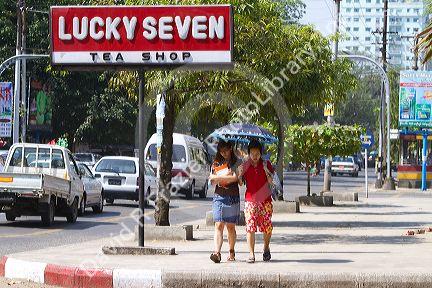 Teenage Burmese girls walk together under the shade of an umbrella in (Rangoon) Yangon, (Burma) Myanmar.
