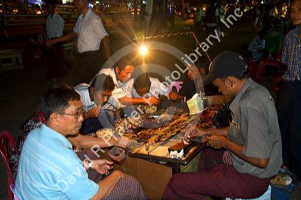 Burmese people eat and drink outdoors near the Sule Paya located in the heart of downtown (Rangoon) Yangon, (Burma) Myanmar.