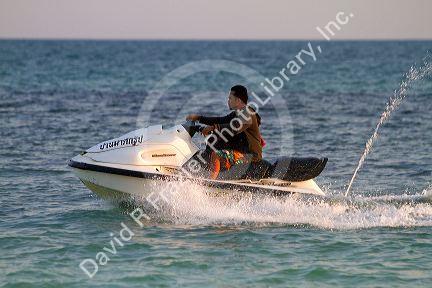Man riding a personal water craft in the Gulf of Thailand at Chaweng beach on the island of Ko Samui, Thailand.