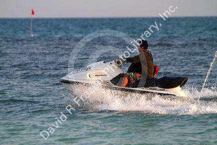 Man riding a personal water craft in the Gulf of Thailand at Chaweng beach on the island of Ko Samui, Thailand.