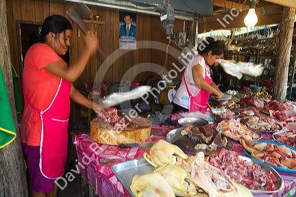 Women chopping and selling meat at an open air market on the island of Ko Samui, Thailand.