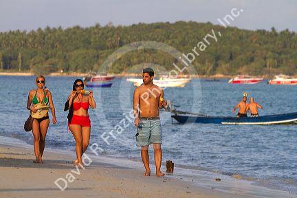Woman eating corn on the cobb at Chaweng beach in the Gulf of Thailand on the island of Ko Samui, Thailand.