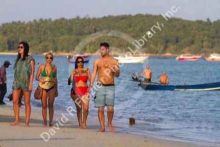 Woman eating corn on the cobb at Chaweng beach in the Gulf of Thailand on the island of Ko Samui, Thailand.