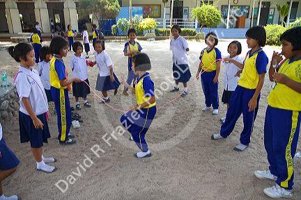 Thai elementary school students jump rope on the island of Ko Samui, Thailand.