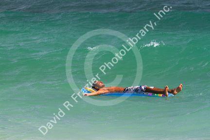 Man floating on an air matress in the Gulf of Thailand at Chaweng beach on the island of Ko Samui, Thailand.