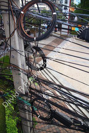 Utility pole with assorted cables and wires in Bangkok, Thailand.