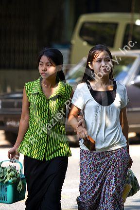 Burmese women walk arm in arm on the street in (Rangoon) Yangon, (Burma) Myanmar.