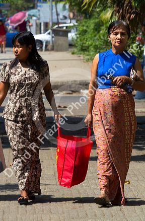 Burmese women sharing the weight of a shopping bag in (Rangoon) Yangon, (Burma) Myanmar.
