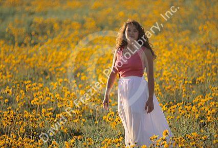 A woman walking through a field of wildflowers in Idaho.